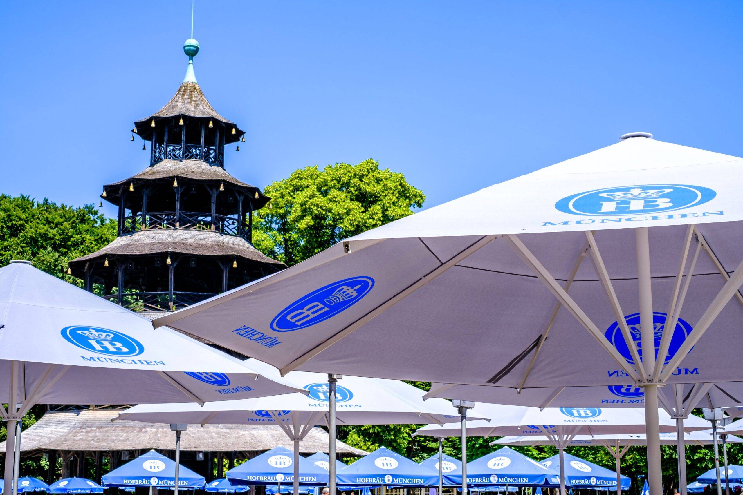 Chinesischer Turm im Englischen Garten München mit Biergarten und Sonnenschirmen an einem Sommertag