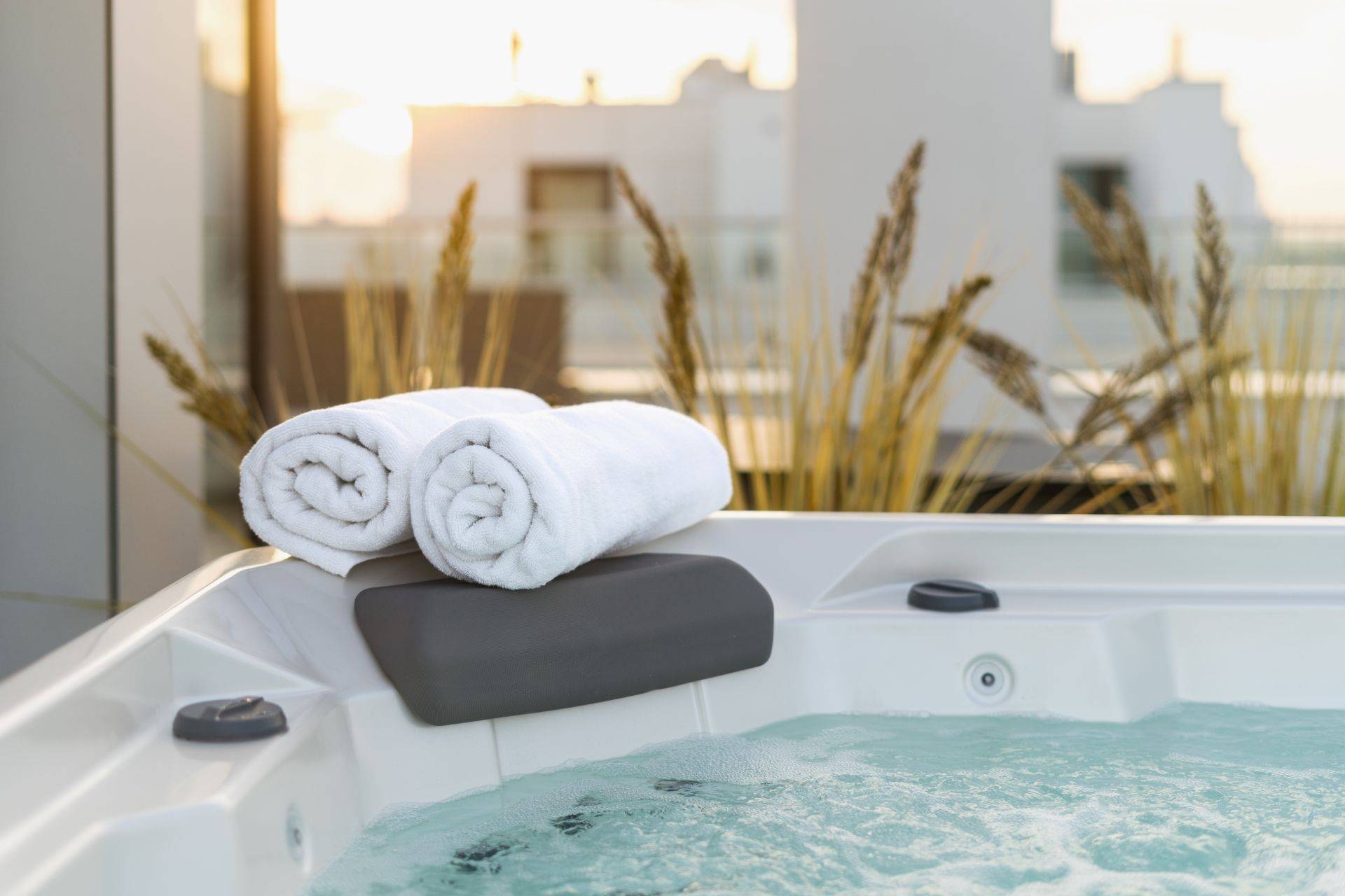 Moderner Whirlpool mit Handtuechern und Sonnenlicht fuer stilvolle Wellnessmomente zu Hause