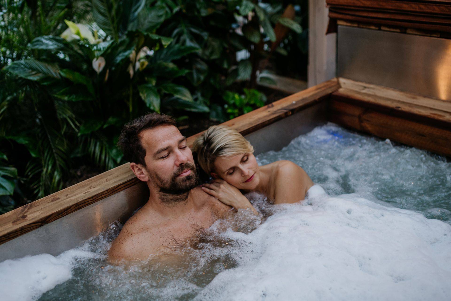 Entspannung im Whirlpool im Garten mit Pflanzen und warmem Wasser fuer mehr Wohlbefinden zu Hause